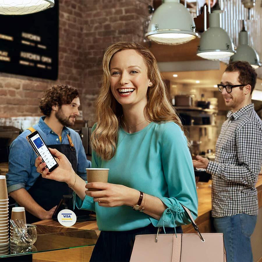 Woman paying by mobile at coffee shop